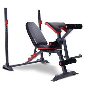 Adjustable weight bench with red and black padding, gray steel frame, and includes leg development attachment and preacher curl pad.