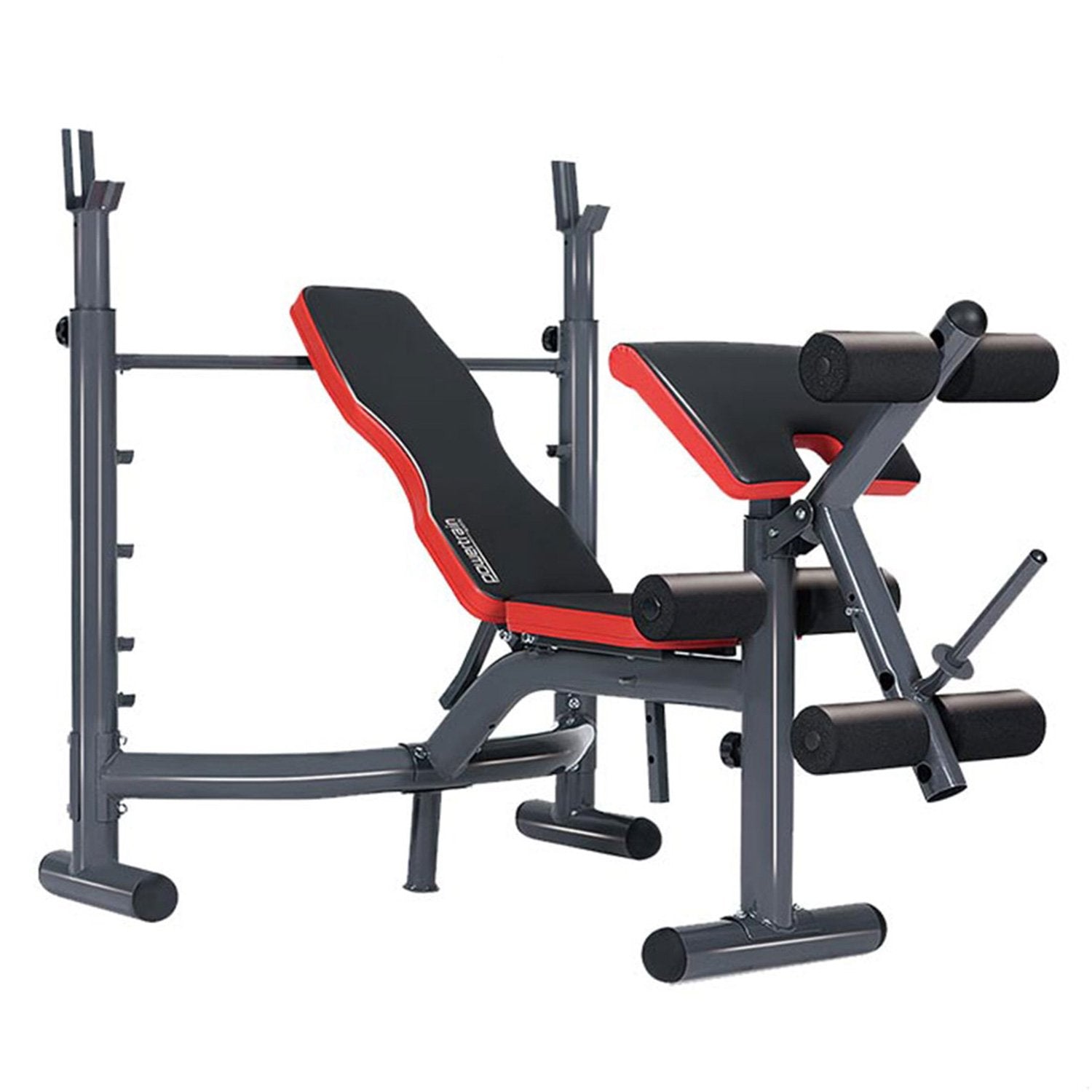 Adjustable weight bench with red and black padding, including an Olympic bar, preacher curl attachment, and leg curl extension.