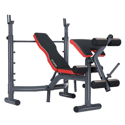 Adjustable weight bench with red and black padding, including an Olympic bar, preacher curl attachment, and leg curl extension.