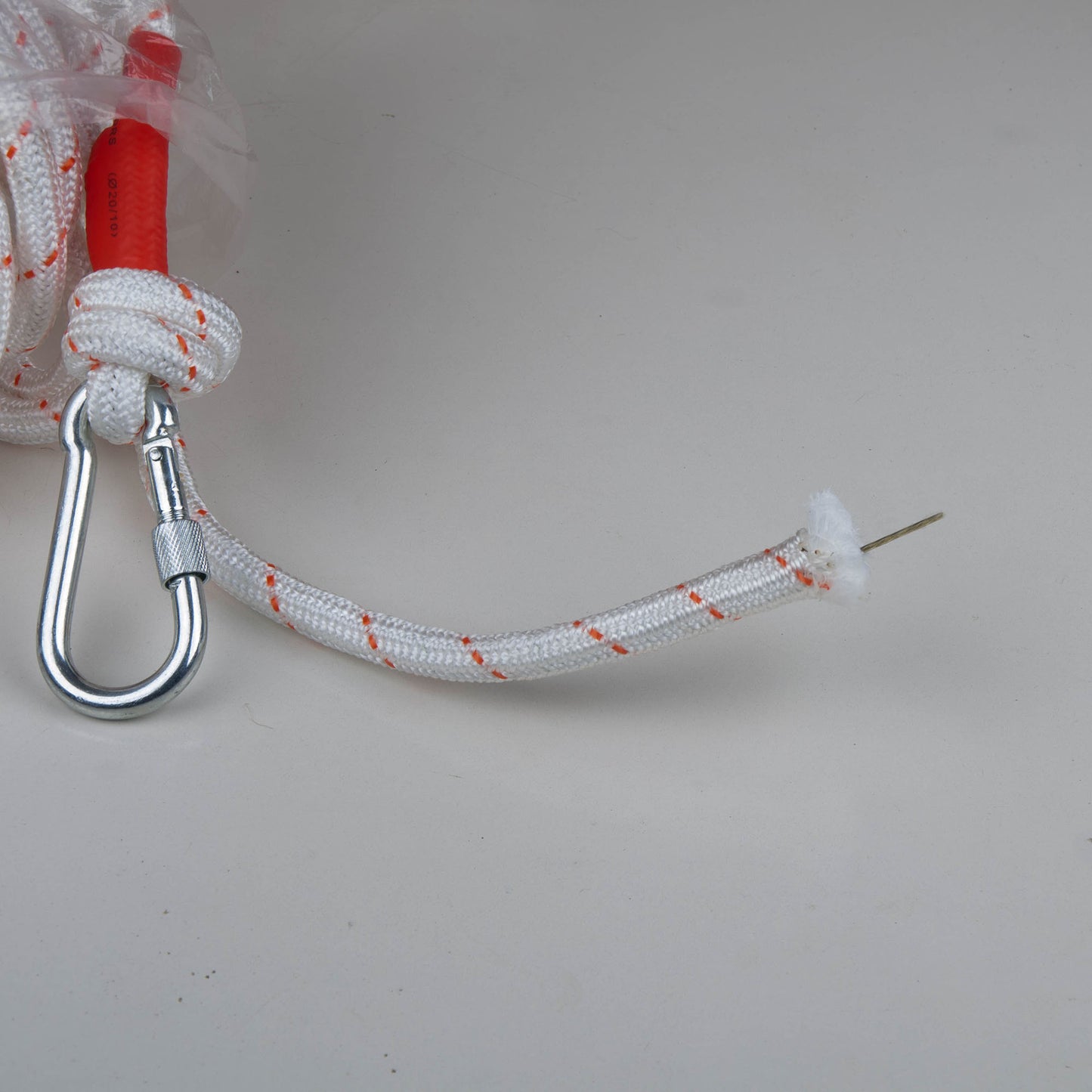 White Climbing Rope with red end and metal carabiner on a light grey background