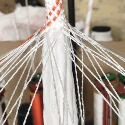 Close-up of a white Climbing Rope with orange accents against a blurred background
