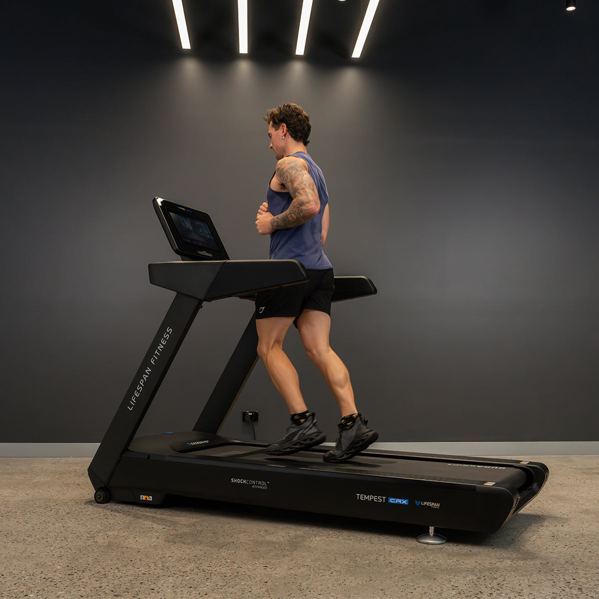Person running on a treadmill in a dark room
