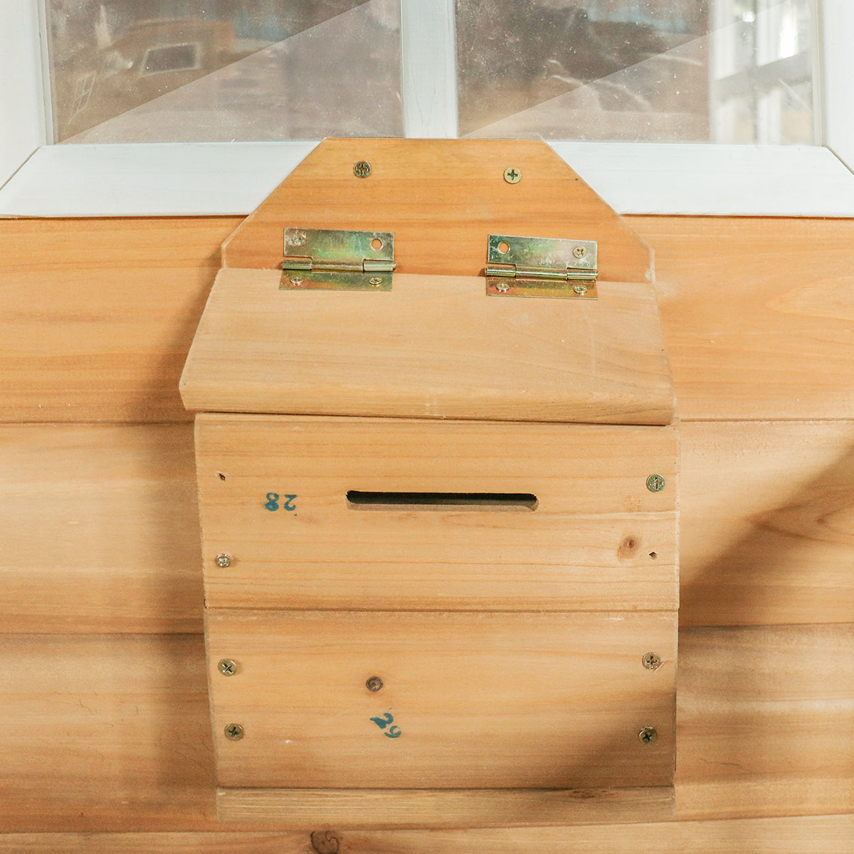 Wooden beehive box with a lid on a wooden surface