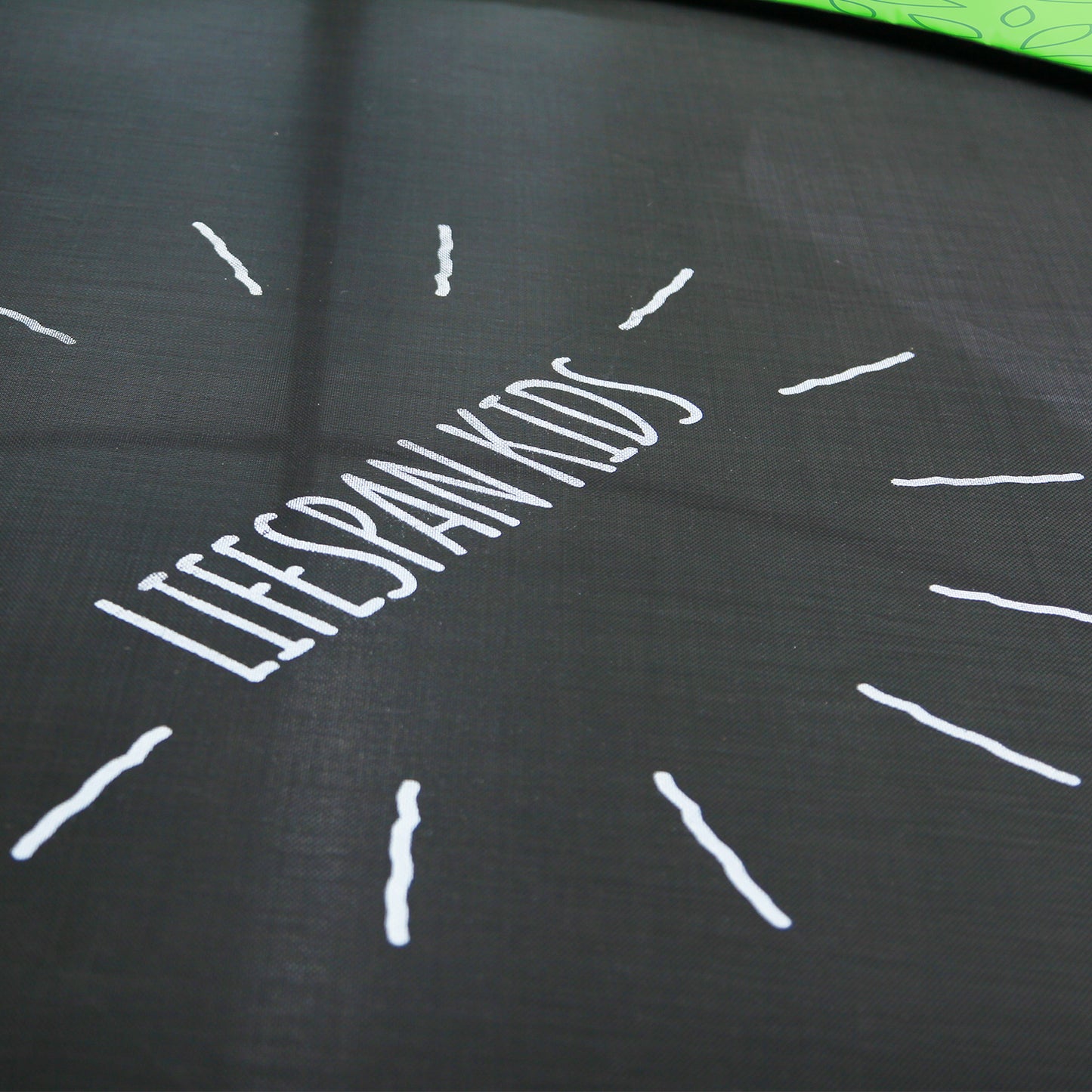 Black fabric with white text 'LIFESPANKIDS' and white lines on a dark background
