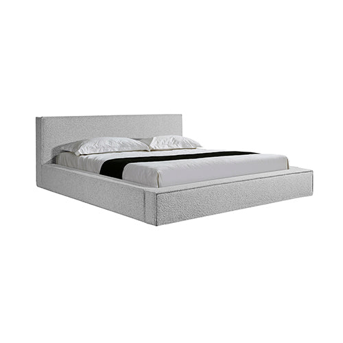 Gray upholstered bed with white bedding on a white background