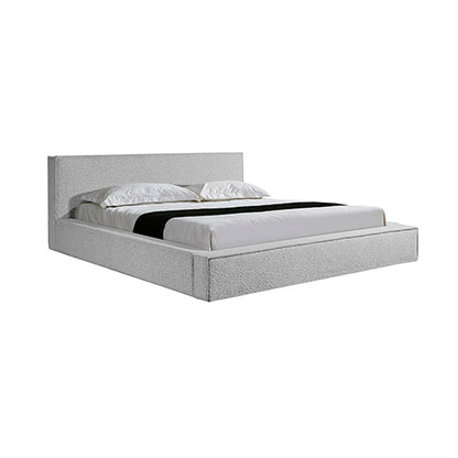 Gray upholstered bed with white bedding on a white background