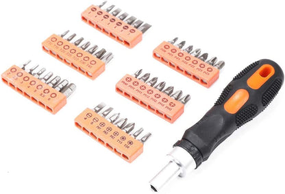 A set of screwdriver bits laid out next to a ratchet screwdriver with a black handle and orange accents. The bits appear to be organized in rows with different types including Phillips, flat slot, and Torx.