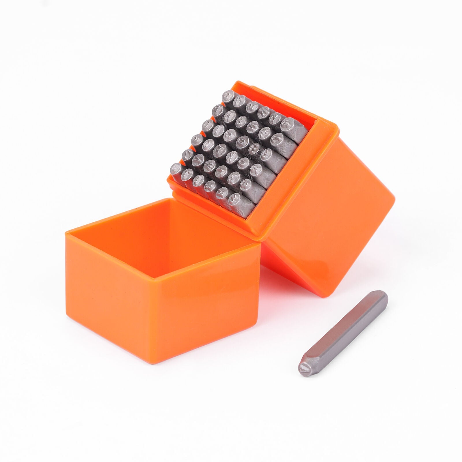 A set of metal punch stamps for crafting, displayed in an orange plastic storage case with the punches arranged neatly. One punch is placed outside of the case, showing the tool's scale.