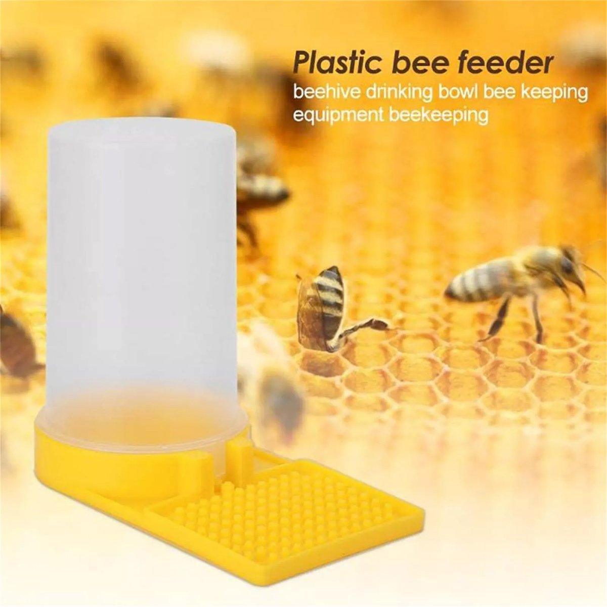 Plastic bee feeder with bees around on a honeycomb background