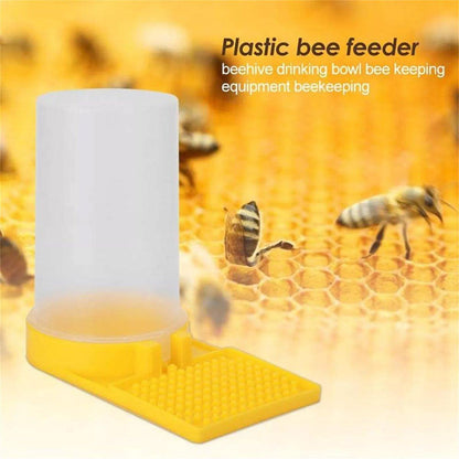 Plastic bee feeder with bees around on a honeycomb background