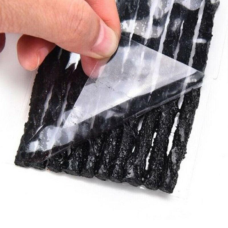 Hand holding a clear plastic Tyre Repair Plugs over a black and white marbled stone