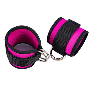 Pair of black and pink wrist cuffs with metal rings on a white background
