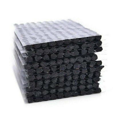 Stack of black tyre Repair Plugs with textured surface on a white background