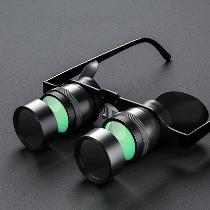 Black fishing binoculars with green accents on the lenses, featuring a detachable barrel and silicone nose pads.