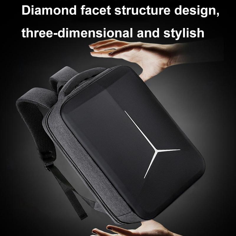 Black backpack with diamond facet design held by hands against a dark background