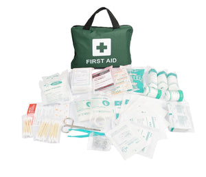 A green first aid kit with a white cross logo, spills out its contents including a variety of medical supplies like plasters, antiseptic wipes, and a CPR mask.