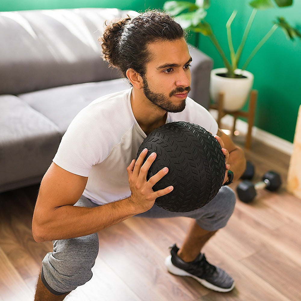 Man exercising with a medicine ball in a home setting