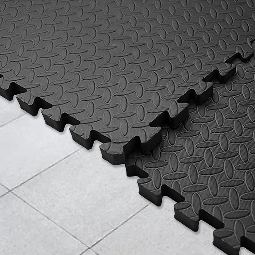 Black interlocking foam mats on a tiled floor
