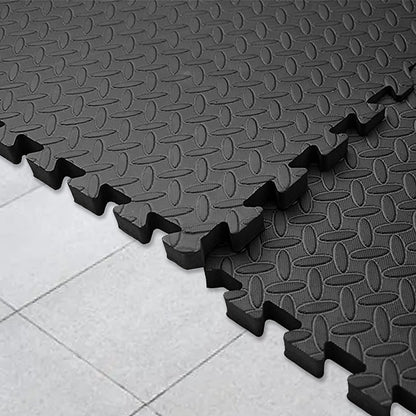 Black interlocking foam mats on a tiled floor
