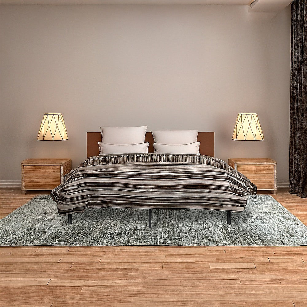 Bedroom with a bed, nightstands, and lamps on a wooden floor.