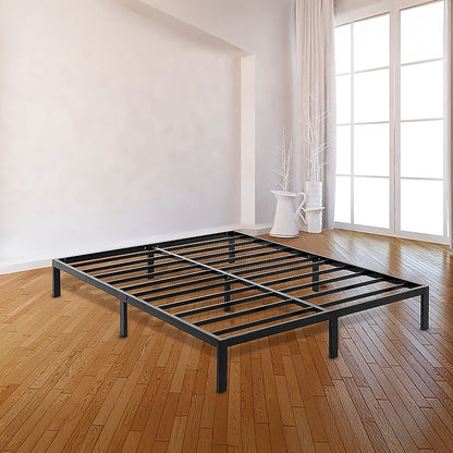 Black metal bed frame in a room with wooden flooring and large windows.