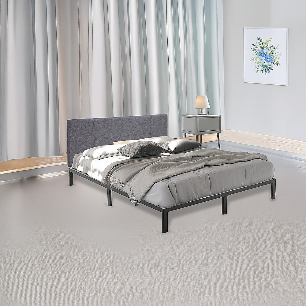 Gray upholstered bed with bedding in a bedroom setting.