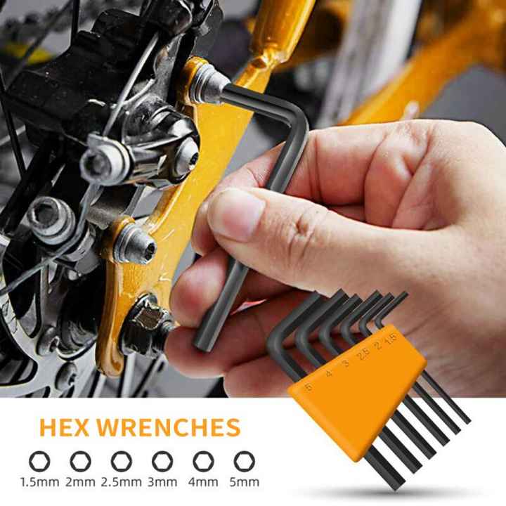 Hand holding a set of hex wrenches near a mechanical component with a close-up view.