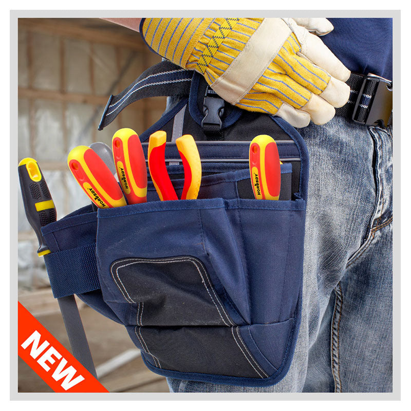 Person wearing a tool belt with various tools, including screwdrivers, in a workshop setting.
