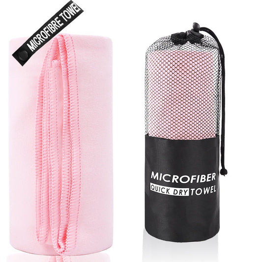 Pink microfiber quick dry towel with black drawstring bag on a white background