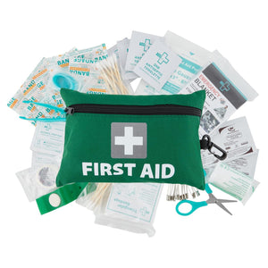 A green first aid kit with a white cross logo, opened to display its contents including bandages, antiseptic wipes, and a pair of scissors.