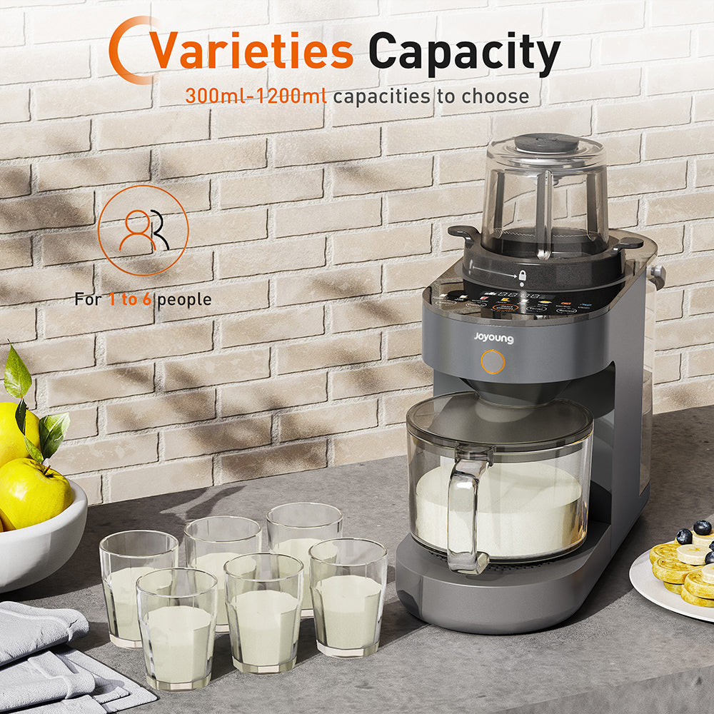 Juicer on a kitchen counter with glasses of juice and lemons, against a brick wall background.