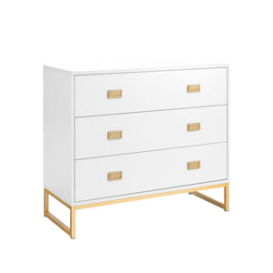 A white chest of drawers with gold handles and legs, featuring three drawers and a sleek design.