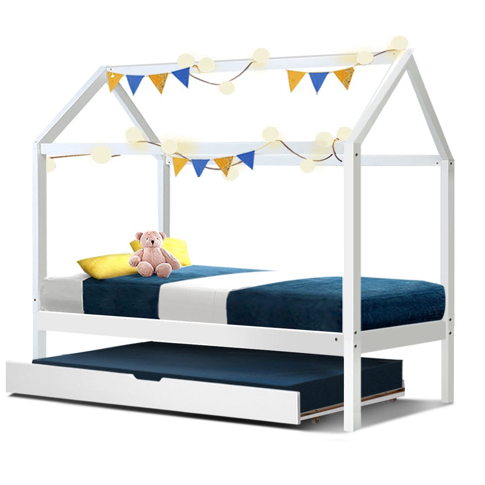 Single sized white wooden bed frame with a house-shaped top and a blue mattress. Decorative flags are strung across the top of the bed frame.